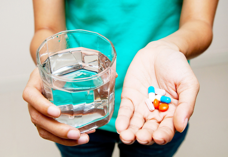 горсть таблеток и стакан воды