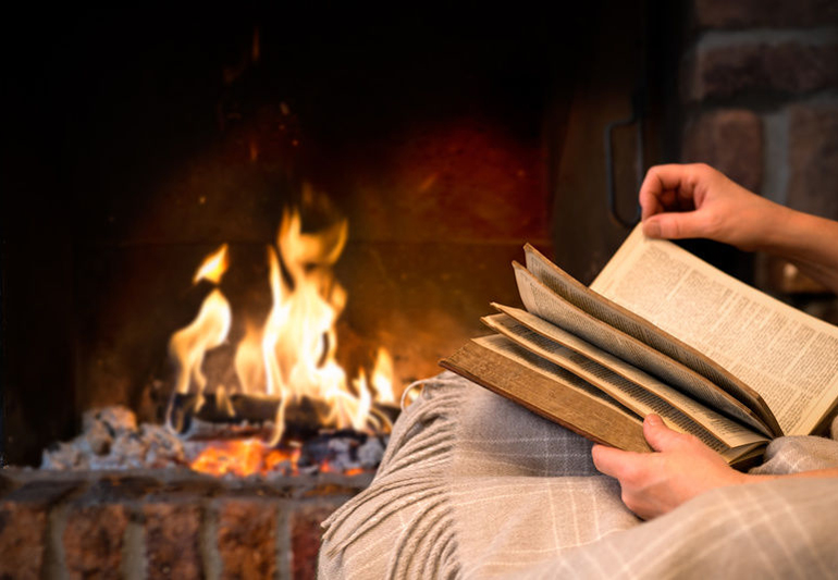 с книгой у камина