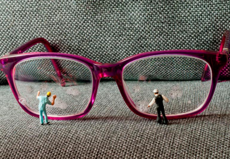 очки на диване и маленькие человечки