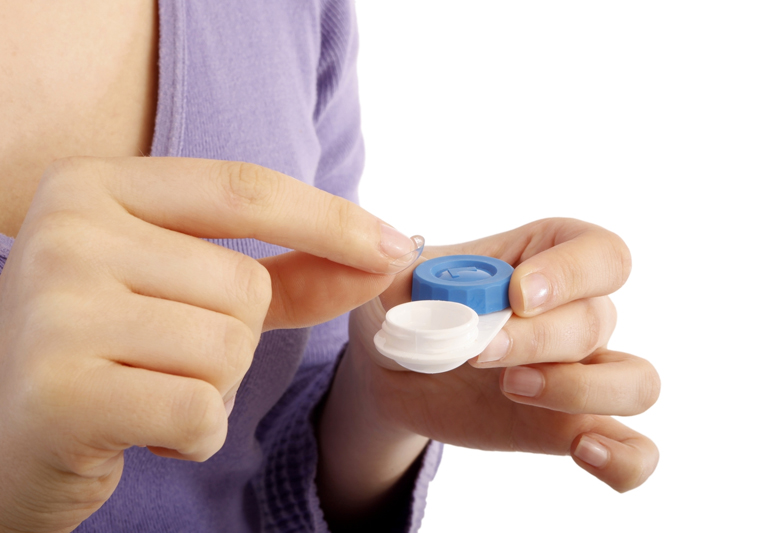 кладет линзу в контейнер